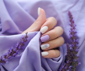 Women's hands with trendy very peri manicure and flowers in purple/ envato/ smile23