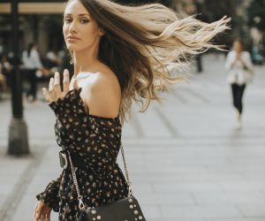 Young long hair brunette woman walking on the street/ envato
