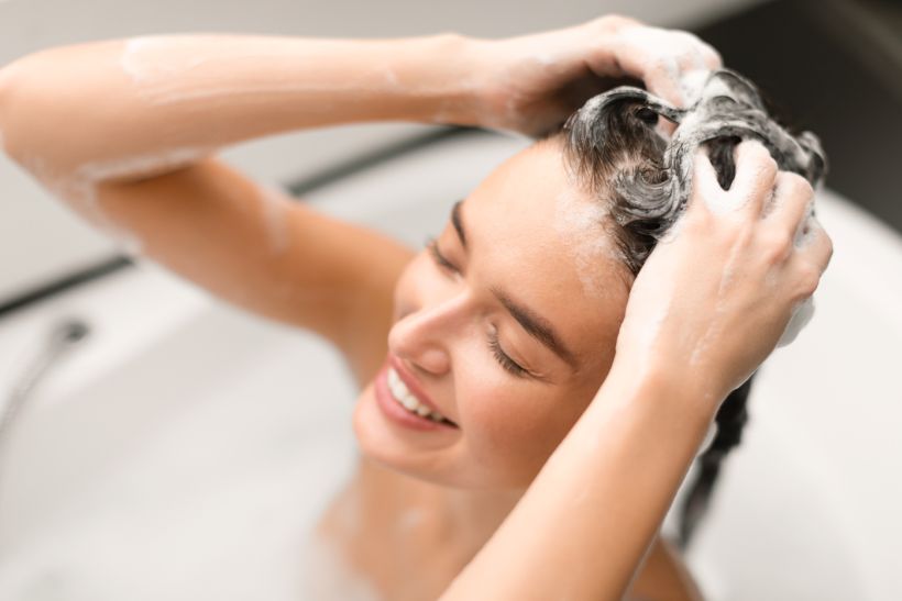 Woman Washing Head Covered With Foam Taking Bath In Bathroom/ envato