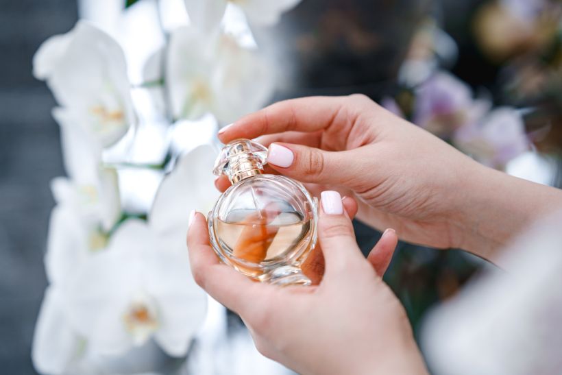 Women's hands hold a bottle of perfume. Elegance and luxury. Eau de Toilette. Cosmetics/ envato / katrinasid