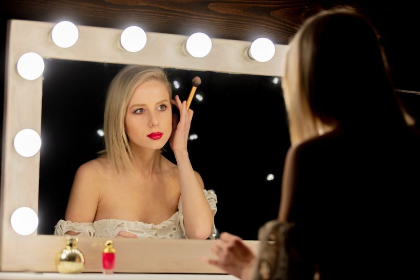 Beautiful blonde woman near makeup mirror. Envato Masson-Simon
